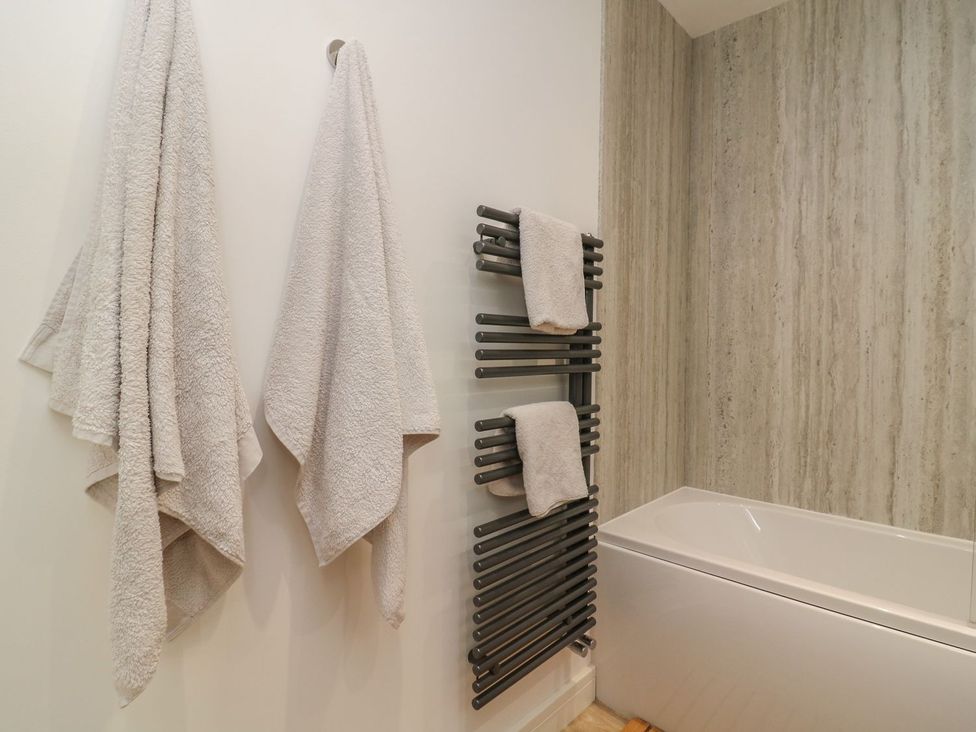 A bathroom with towels on a rack and bath at The Lookout 