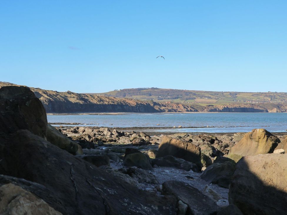 A view of rocks by the sea with hills in the background at The Lookout