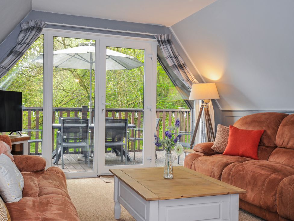 A living room with a television and sofa at Hideaway Cottage in St Ann's Chapel, Cornwall