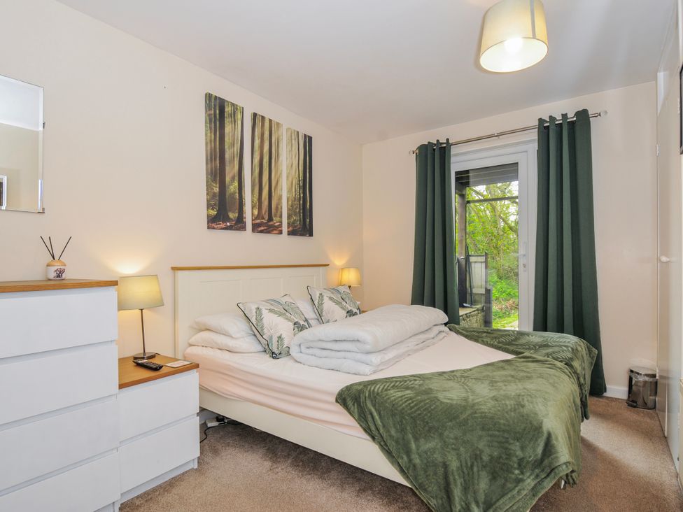 A bedroom with a bed and dresser at Hideaway Cottage St Ann's Chapel, Cornwall