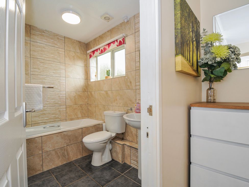A bathroom with a tub, toilet, sink and cabinet at Hideaway Cottage St Ann's Chapel Cornwall