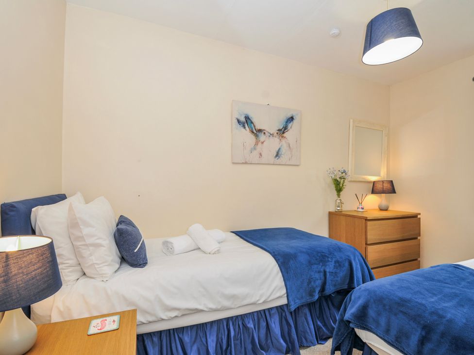 A bedroom with two beds and a chest of drawers at Hideaway Cottage in St Ann's Chapel, Cornwall