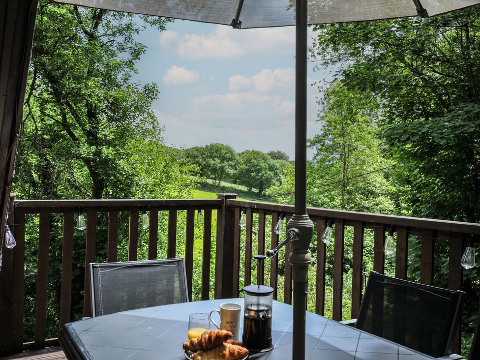 A table with drinks and pastries on a balcony at Hideaway Cottage, St Ann's Chapel, Cornwall