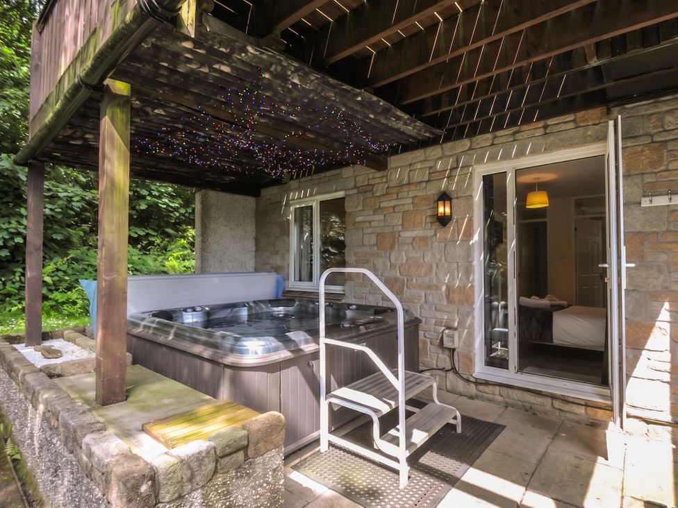 A hot tub with steps on a patio at Hideaway Cottage, St Ann's Chapel, Cornwall