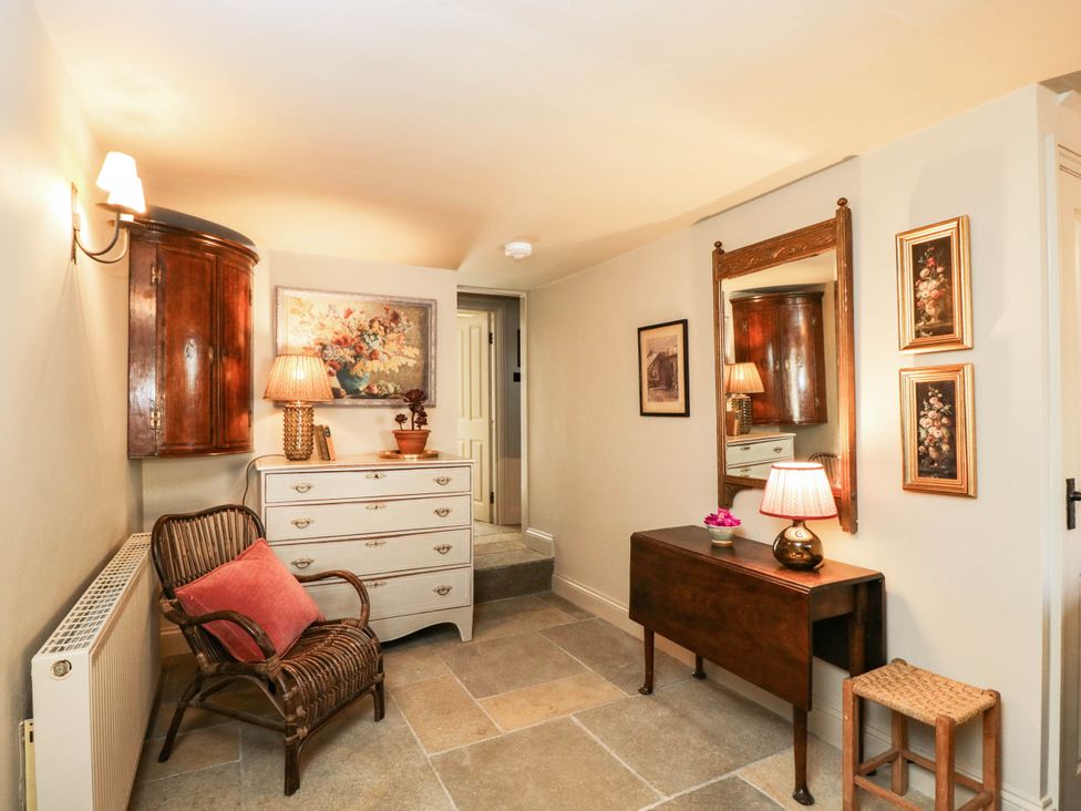 A hallway with a chest of drawers and a mirror at Mallards in Bourton-On-The-Water