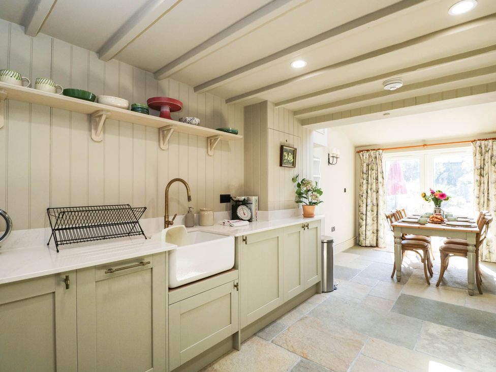 A kitchen with a sink and dining table at Mallards in Bourton-On-The-Water