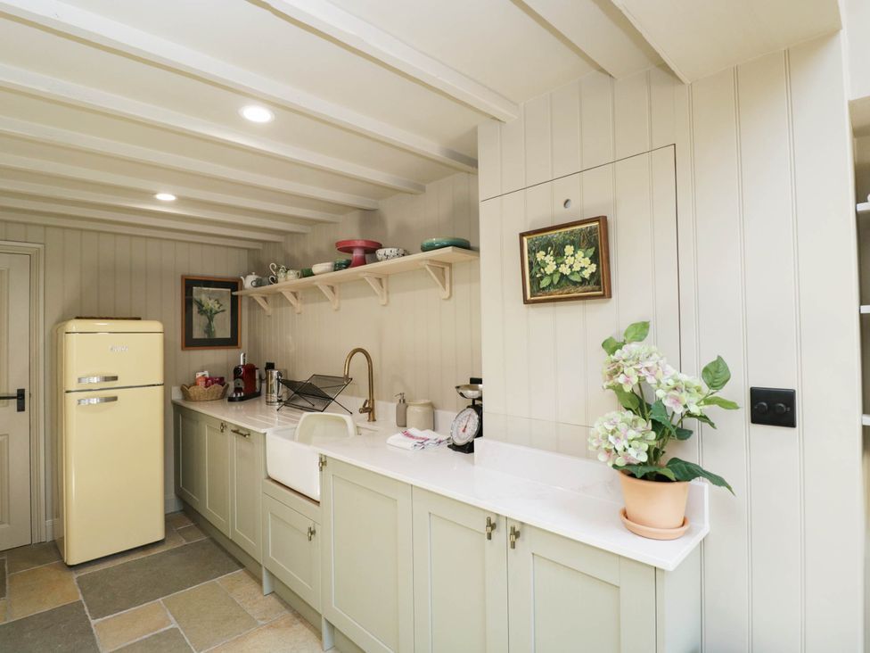 A kitchen with a yellow fridge and a sink at Mallards in Bourton-On-The-Water
