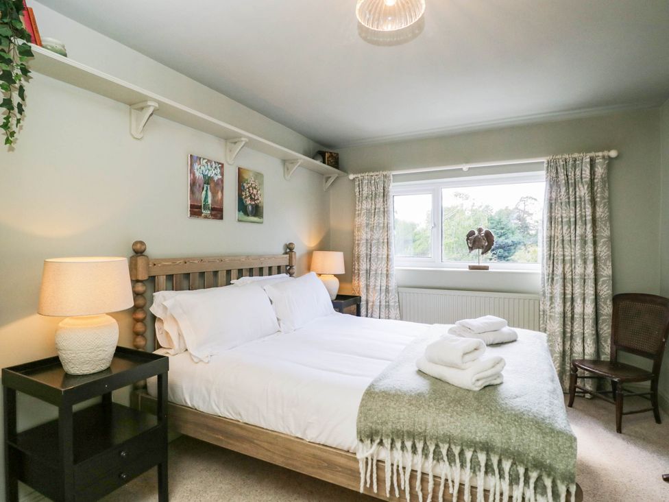 A bedroom with a bed and nightstand at Mallards Bourton-On-The-Water