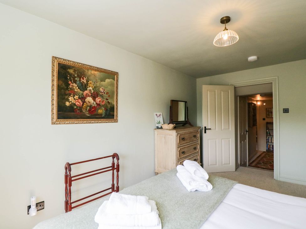 A bedroom with a bed and dresser at Mallards in Bourton-On-The-Water