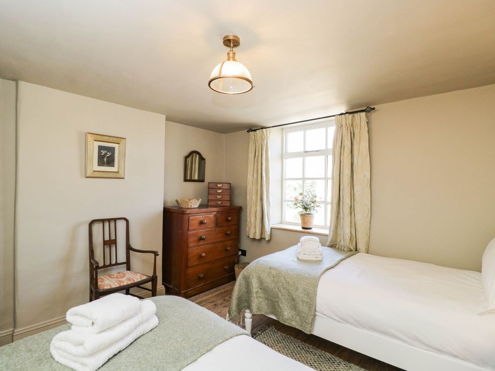 A bedroom with two beds and a dresser at Mallards in Bourton-On-The-Water