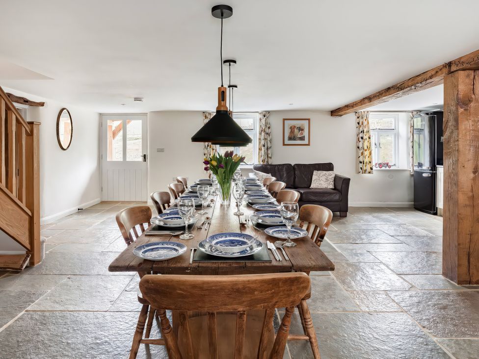 A dining room with a large table set for dinner at Middle Dean Farmhouse Trentishoe near Parracombe