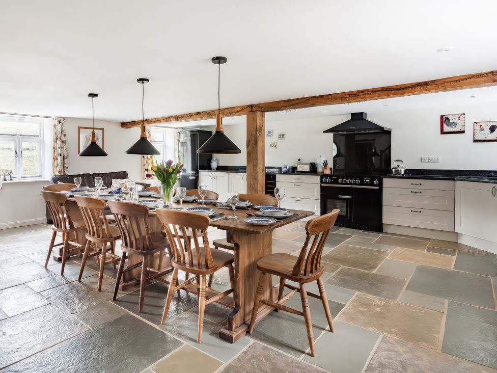 A kitchen with a dining table and chairs at Middle Dean Farmhouse in Trentishoe near Parracombe