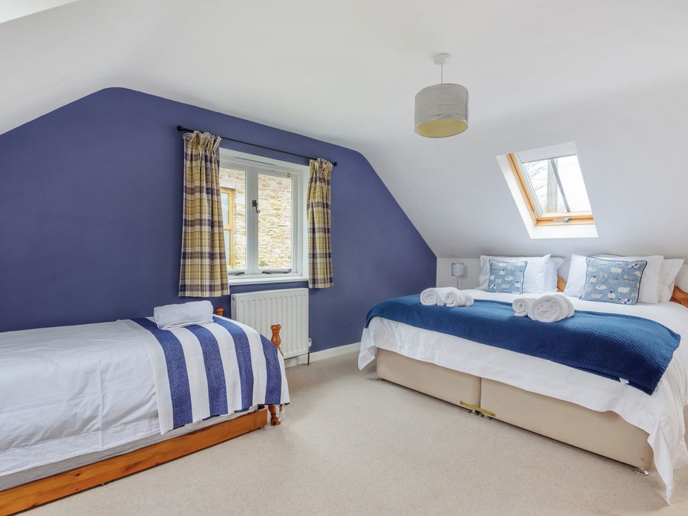 A bedroom with two beds and a window at Middle Dean Farmhouse in Trentishoe near Parracombe