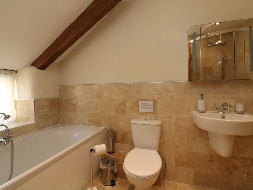 A bathroom with a bathtub, toilet, and sink at Middle Dean Farmhouse, Trentishoe near Parracombe