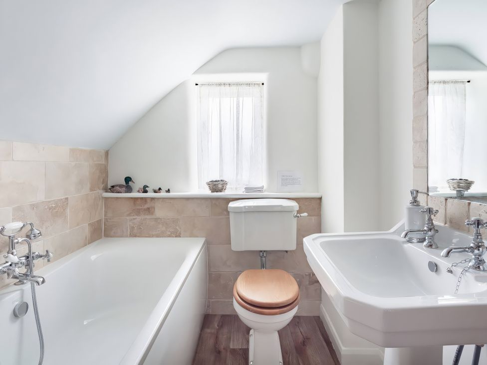 A bathroom with a bathtub, sink, and toilet at Middle Dean Farmhouse in Trentishoe near Parracombe