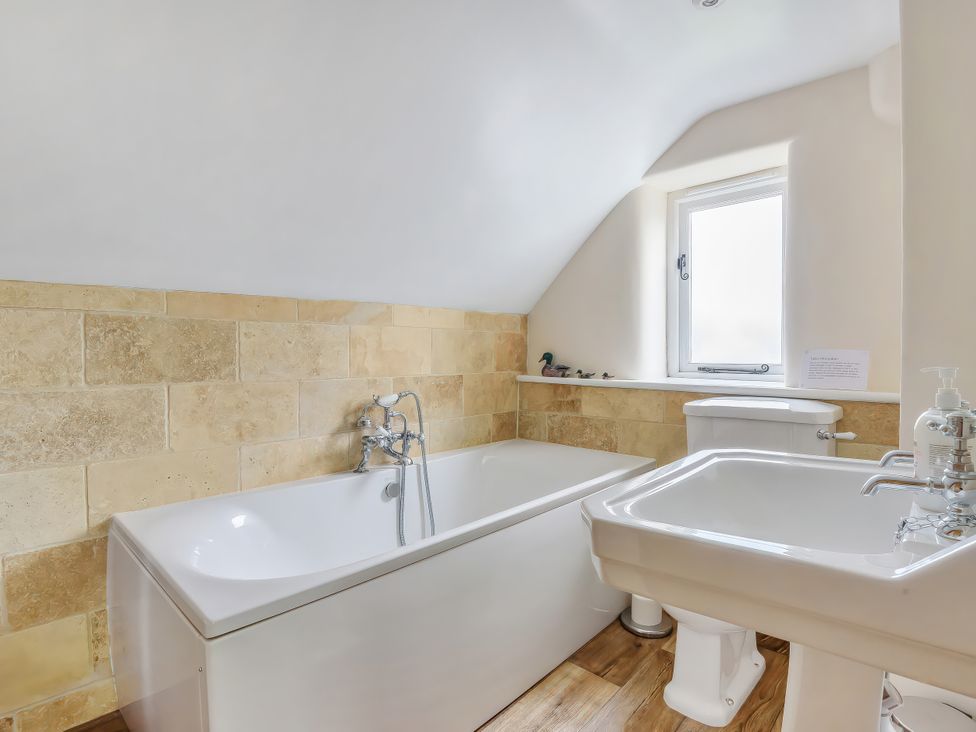 A bathroom with a bathtub, sink, and toilet at Middle Dean Farmhouse near Trentishoe