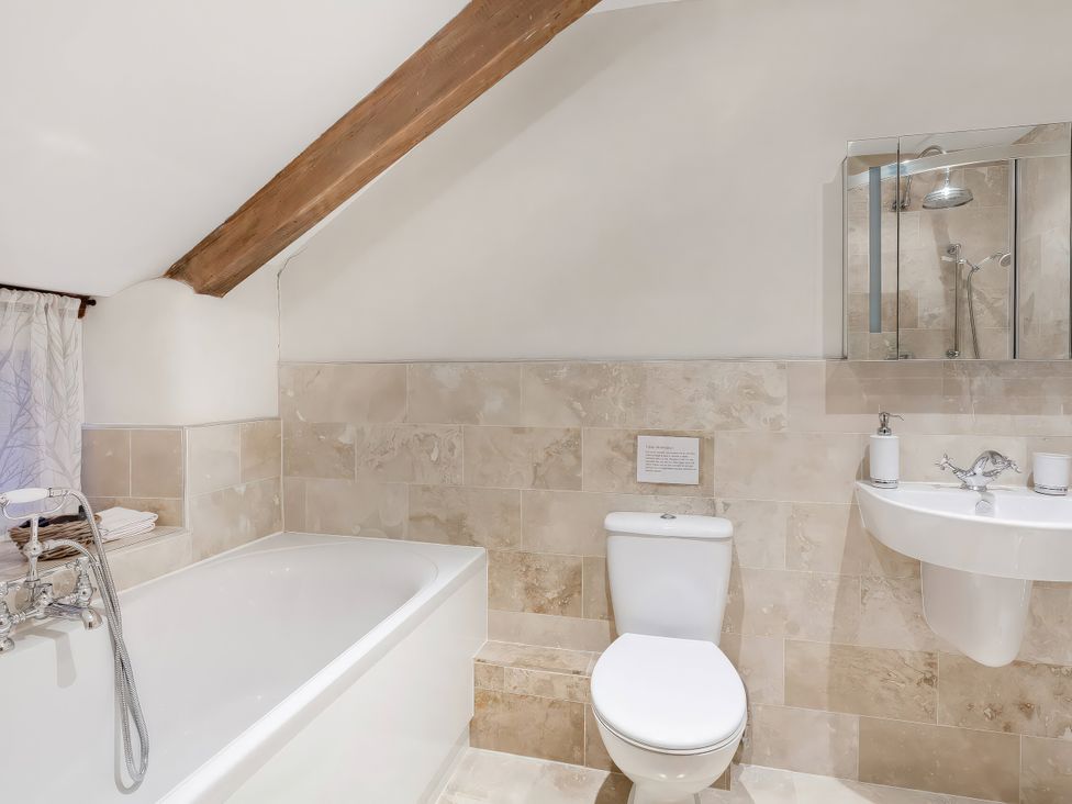 A bathroom with a bathtub and a shower at Middle Dean Farmhouse Trentishoe near Parracombe