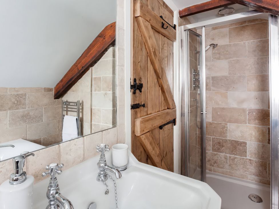 A bathroom with a bathtub and shower at Middle Dean Farmhouse Trentishoe near Parracombe