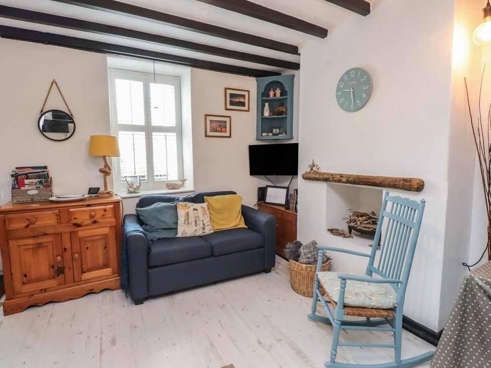 A living room with a sofa and a coffee table at Menuchah in Criccieth