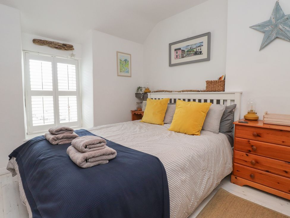A bedroom with a bed and dresser at Menuchah in Criccieth
