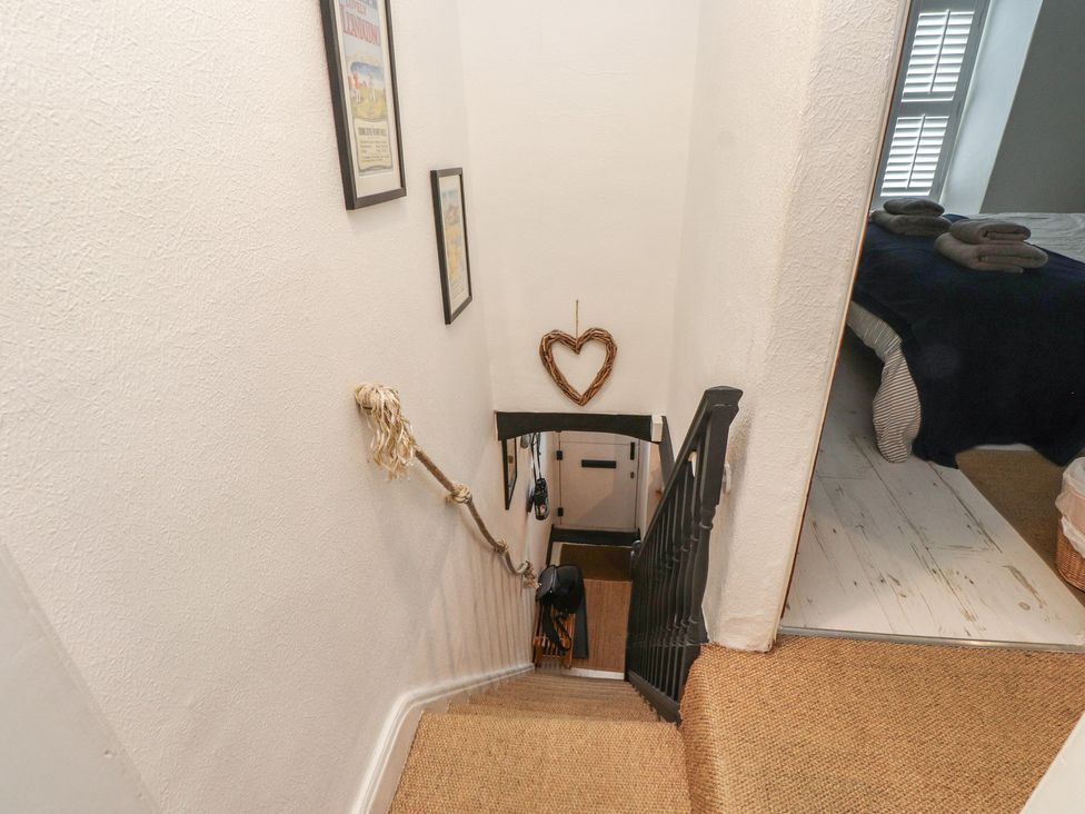 A staircase with wall decorations leading to a bedroom at Menuchah in Criccieth