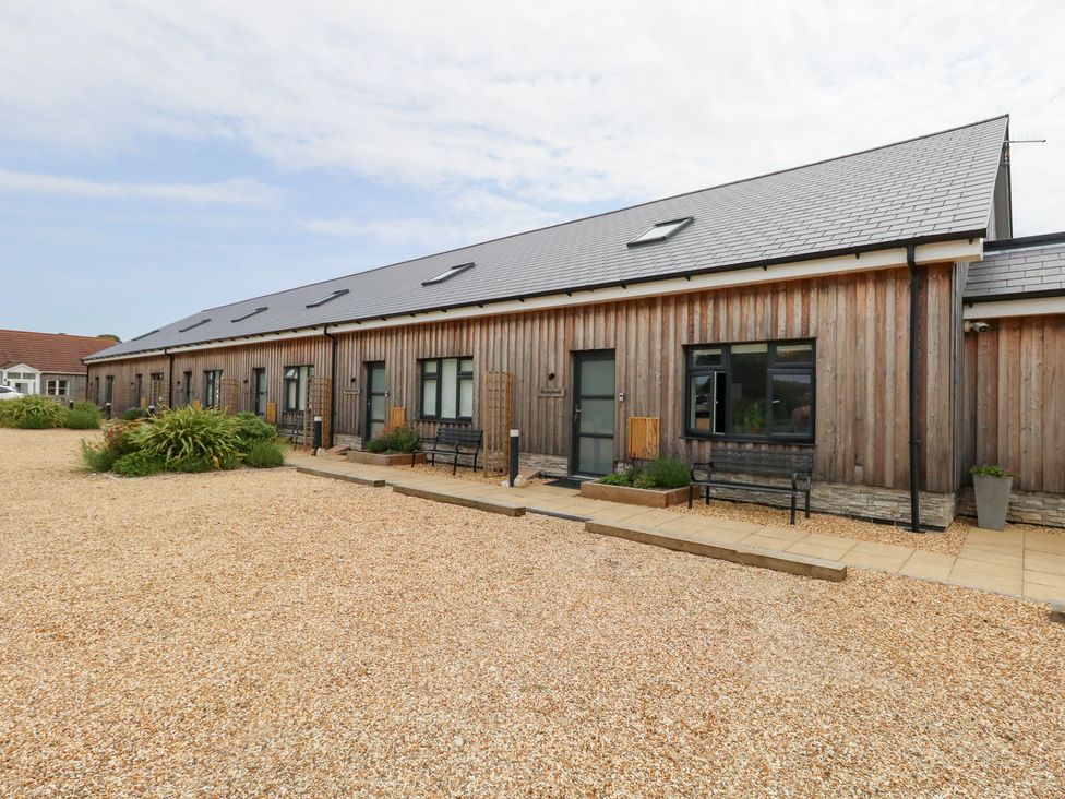 A wooden building with benches and gravel area at Durbyfield Nottington near Weymouth