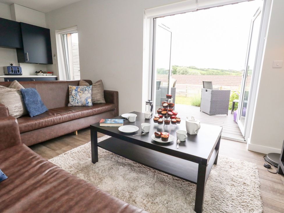 A living room with cupcakes on a table at Durbyfield in Nottington near Weymouth