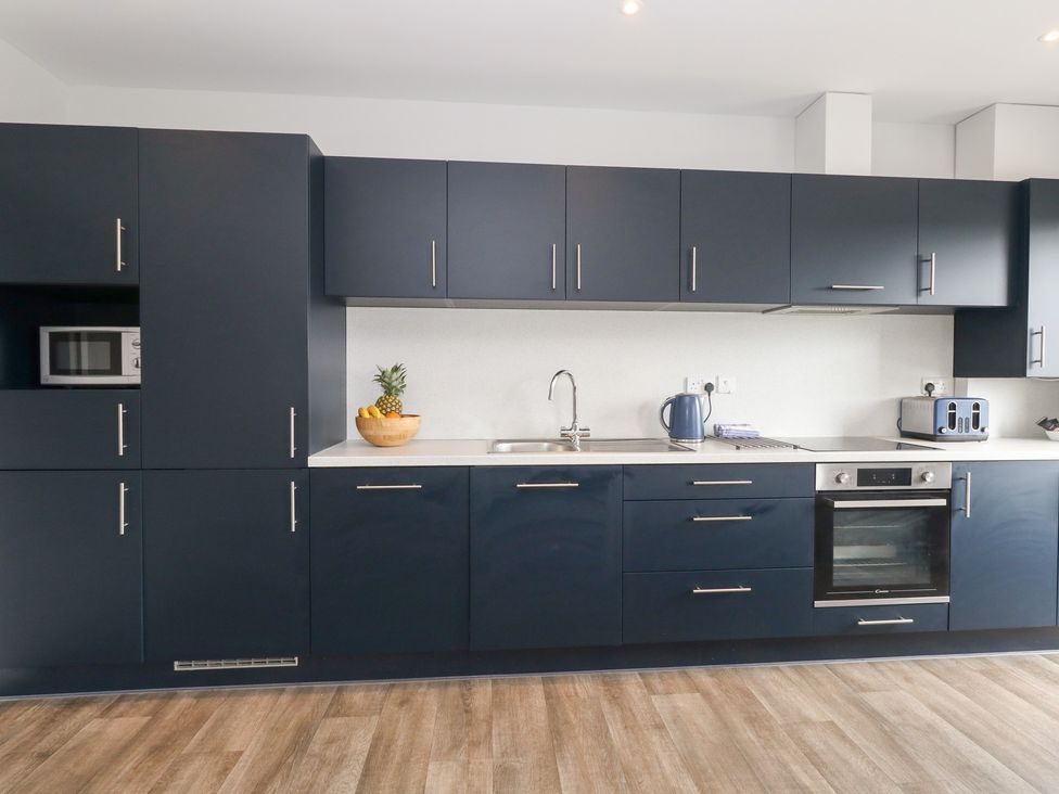 A kitchen with dark cabinets and appliances at Durbyfield Nottington near Weymouth