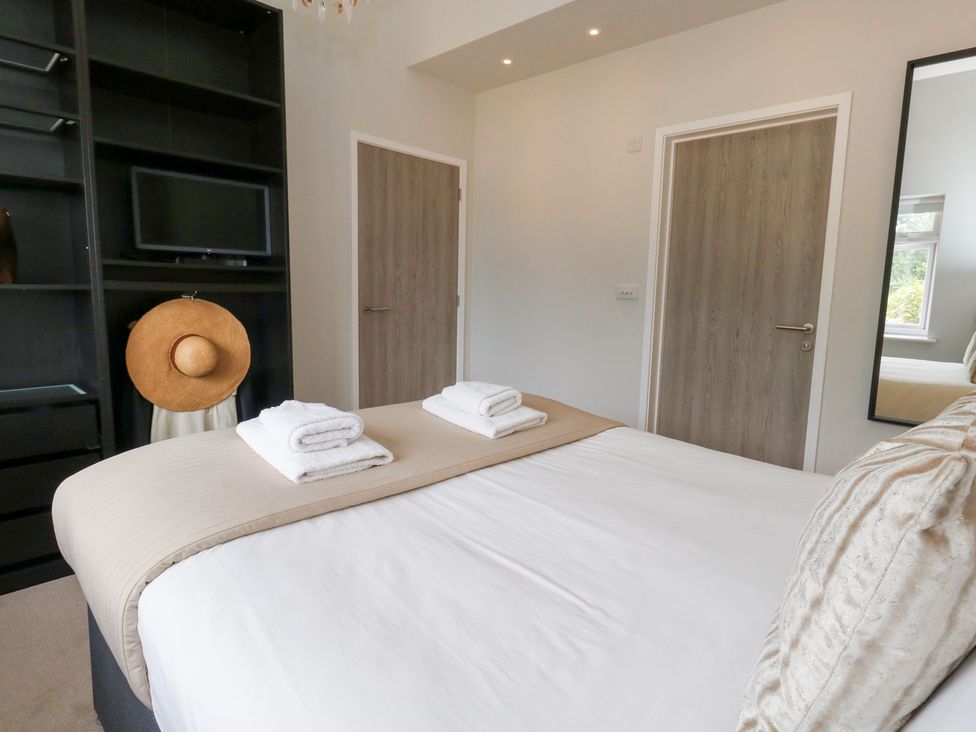 A bedroom with a bed, towels and a television at Durbyfield in Nottington near Weymouth