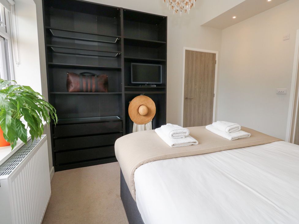 A bedroom with a bed, towels on the bed, and a plant at Durbyfield, Nottington near Weymouth