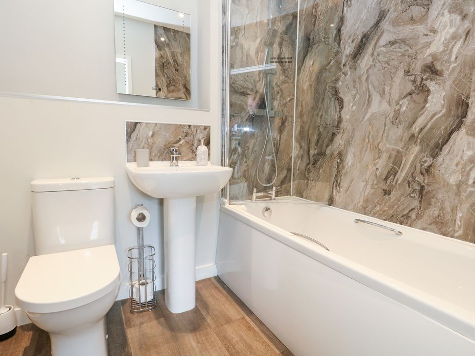 A bathroom with a toilet, sink, and bath at Durbyfield in Nottington near Weymouth