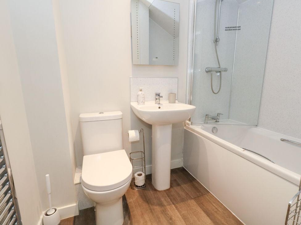 A bathroom with a bathtub, toilet, and sink at Durbyfield in Nottington near Weymouth