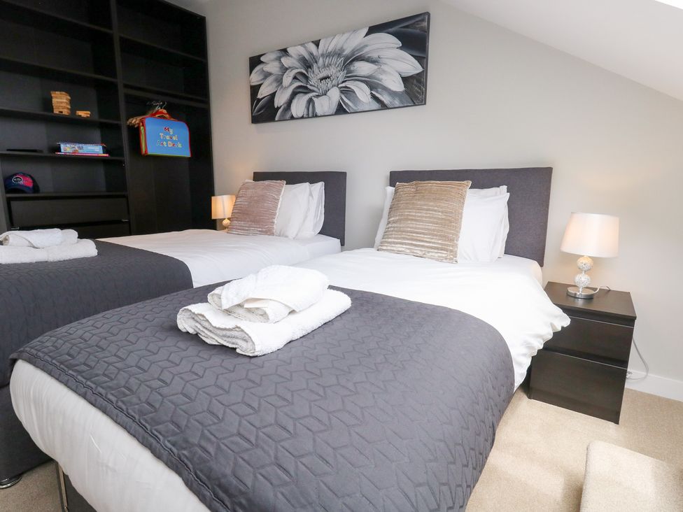 A bedroom with two beds and a bookshelf at Durbyfield in Nottington near Weymouth