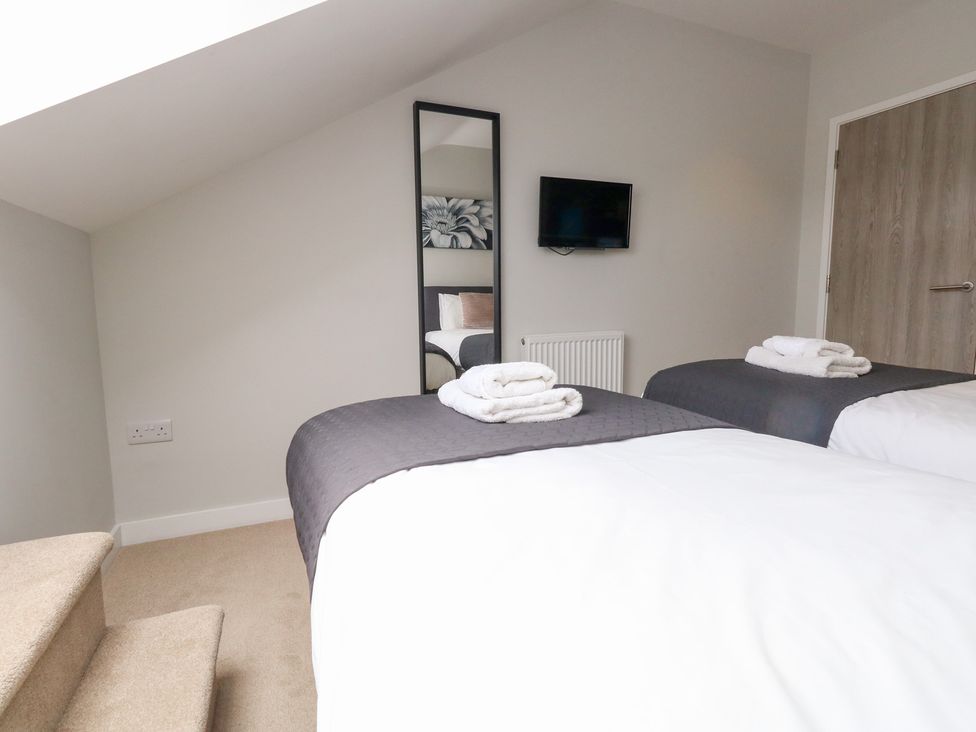 A bedroom with two beds and a TV at Durbyfield in Nottington near Weymouth