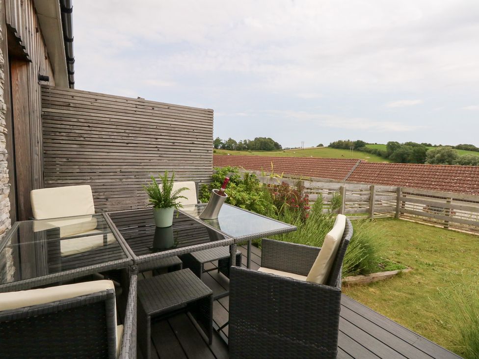 An outdoor patio with table and chairs at Durbyfield in Nottington near Weymouth