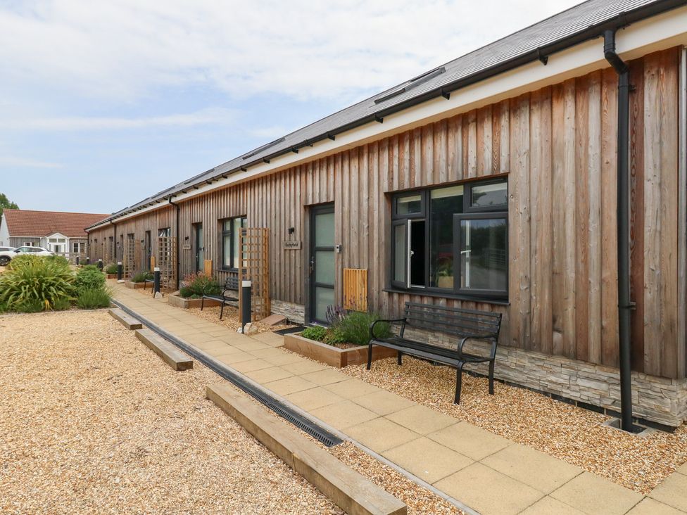 An outdoor area with a wooden building and benches at Durbyfield Nottington near Weymouth