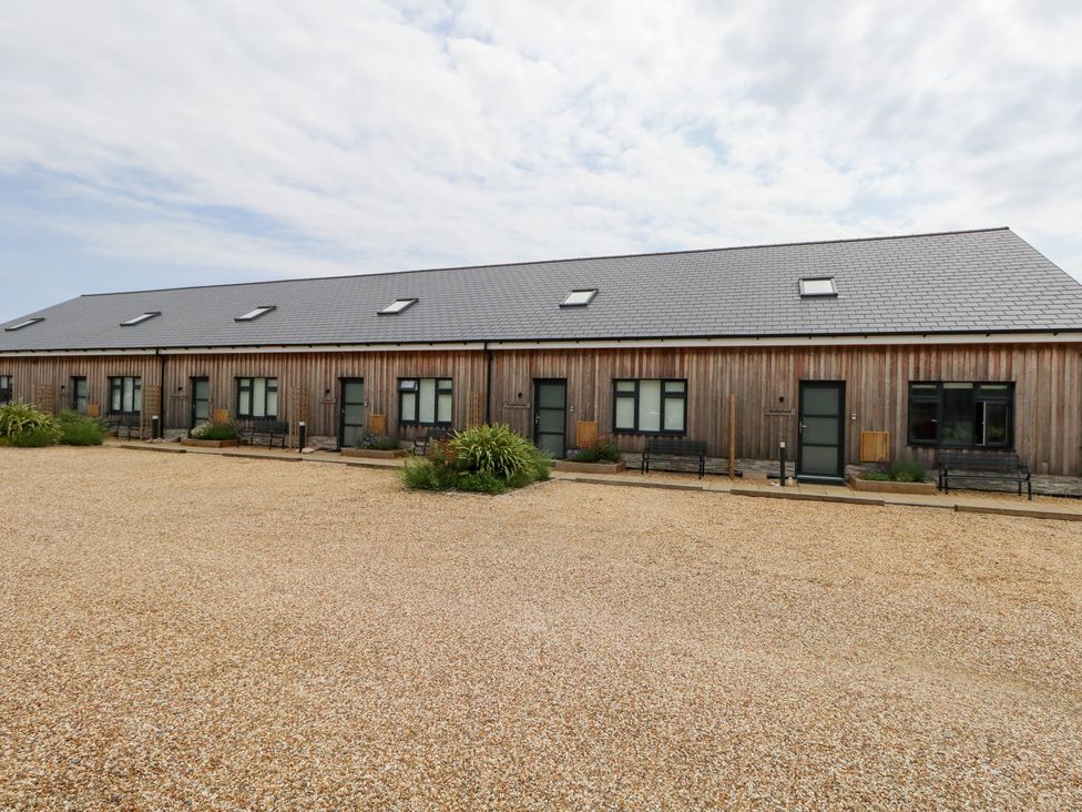 A row of wooden buildings with windows and doors at Durbyfield in Nottington near Weymouth