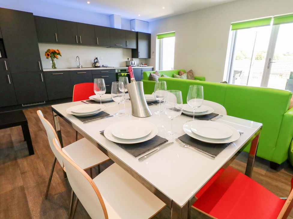 A kitchen with a dining table set for a meal at Overcombe Mill in Nottington near Weymouth