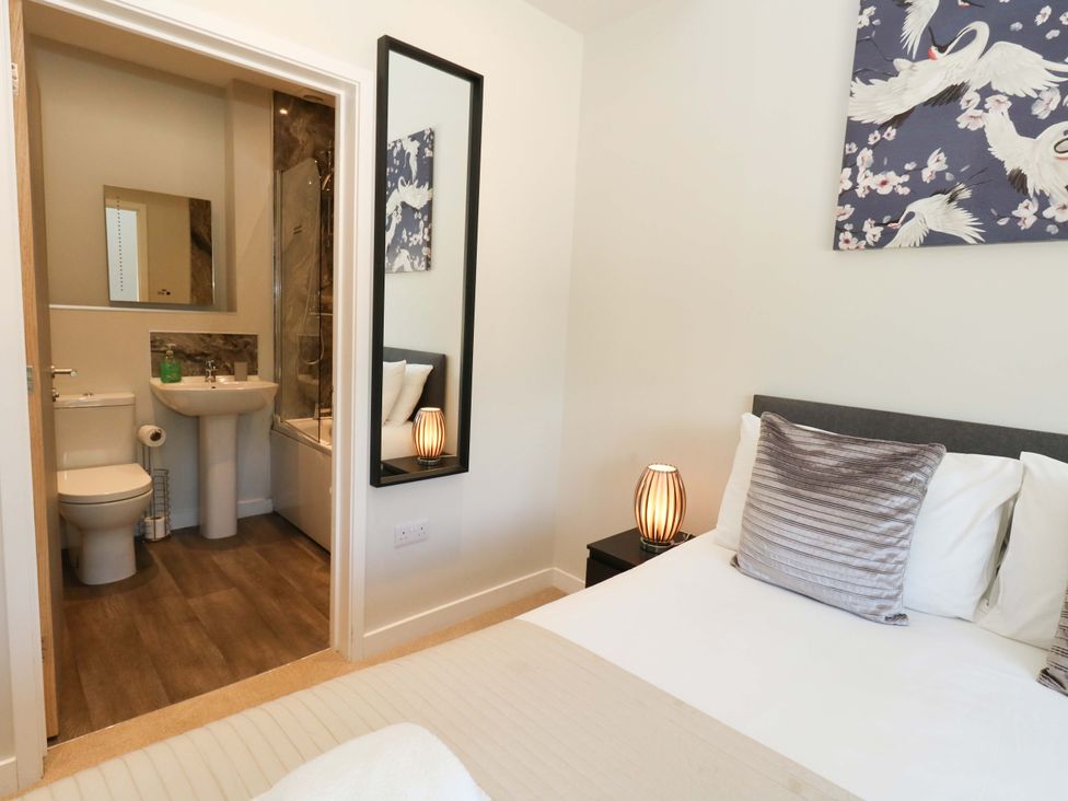 A bedroom with a bed and an ensuite bathroom at Overcombe Mill near Weymouth