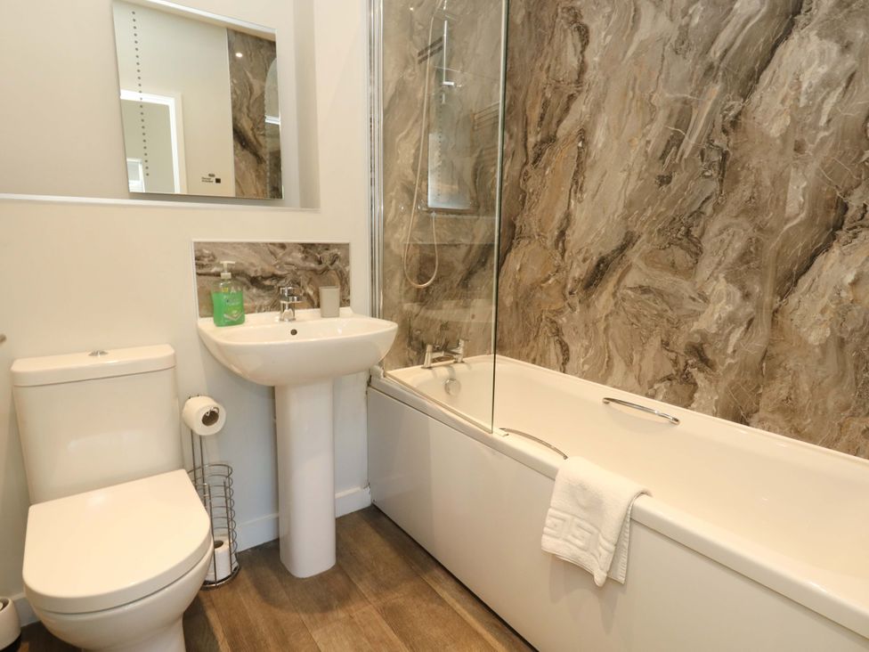 A bathroom with a toilet, sink, and bathtub at Overcombe Mill in Nottington near Weymouth
