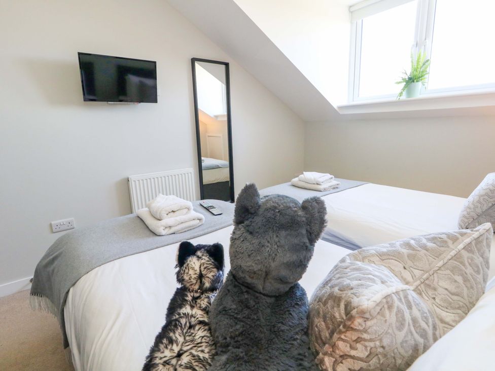 A bedroom with two beds and a TV at Overcombe Mill Nottington near Weymouth