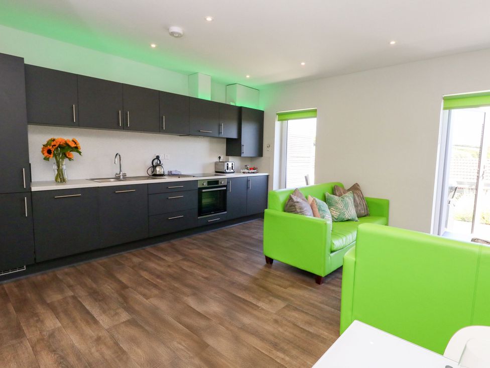 A kitchen with a sink and green couch at Overcombe Mill in Nottington near Weymouth