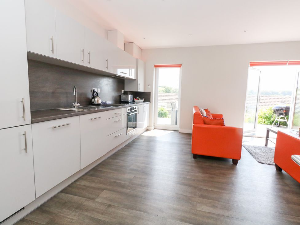 A kitchen with appliances and seating area at Corvesgate Nottington near Weymouth