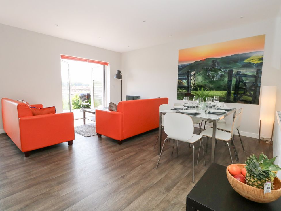 A living room with a sofa and dining table at Corvesgate in Nottington near Weymouth