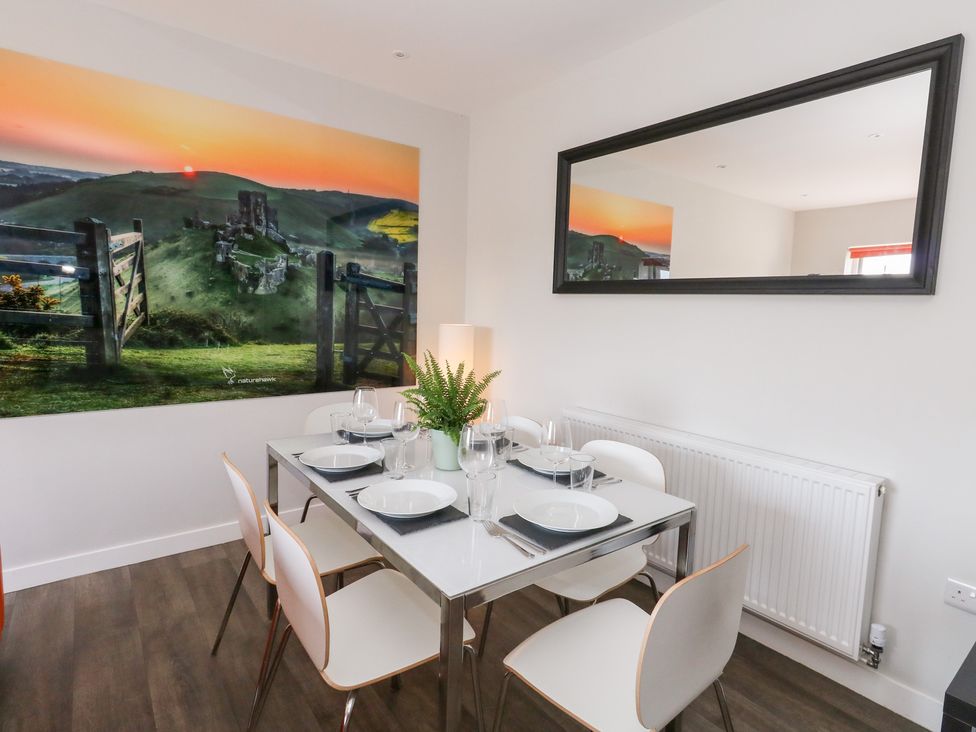 A dining room with a table and chairs at Corvesgate Nottington near Weymouth