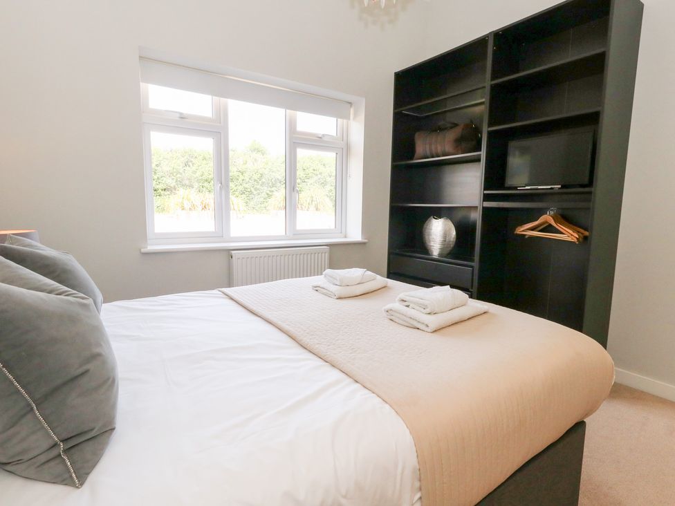 A bedroom with a bed and shelf unit at Corvesgate in Nottington near Weymouth
