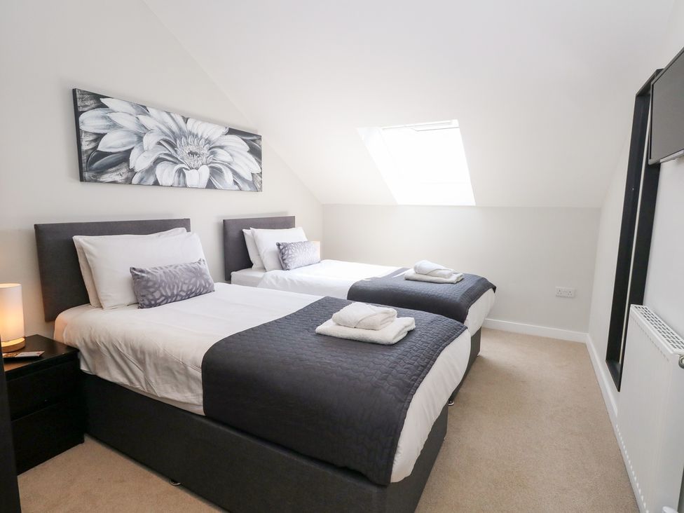 A bedroom with two beds and a window at Corvesgate in Nottington near Weymouth