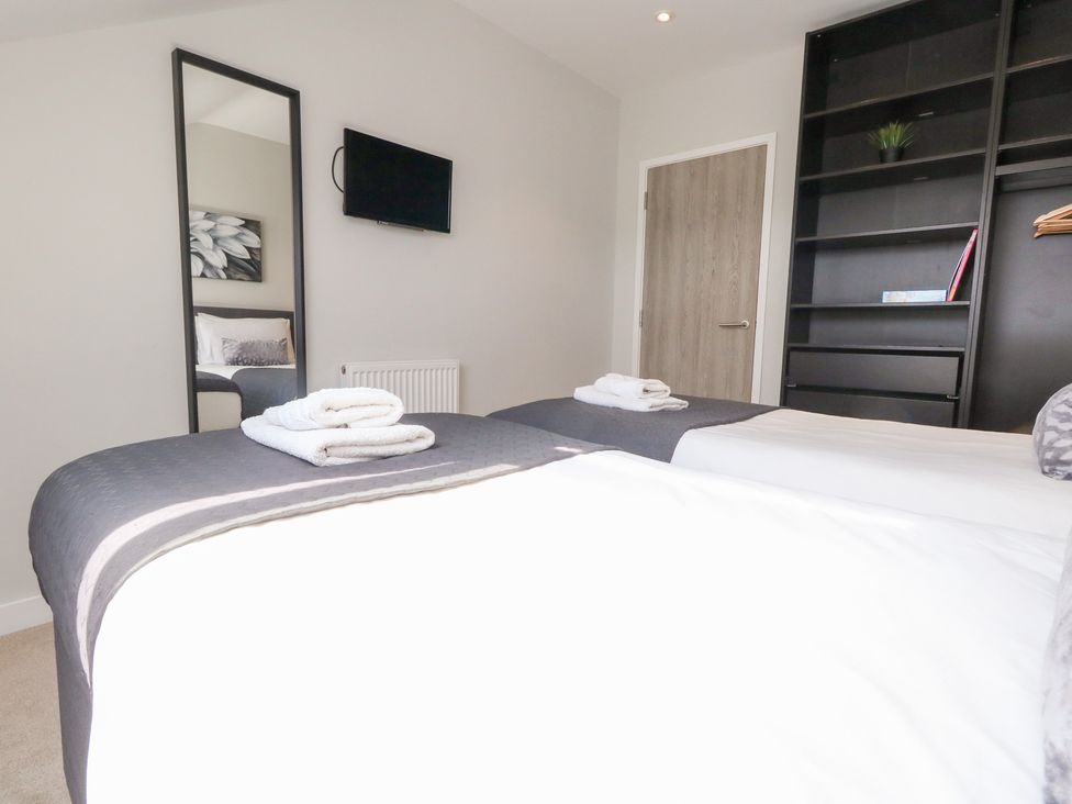 A bedroom with two beds and a television at Corvesgate Nottington near Weymouth