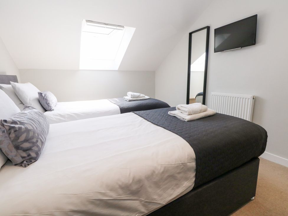 A bedroom with two beds and a television at Corvesgate Nottington near Weymouth