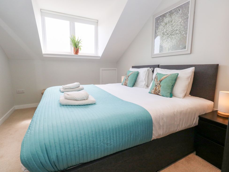 A bedroom with a bed and plant in a window at Corvesgate Nottington near Weymouth